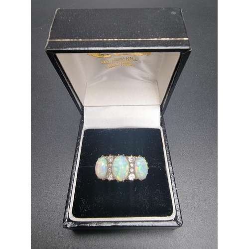 174 - A yellow metal ring, set three cabochon opals and eight graduated mine cut diamonds, size O.... 