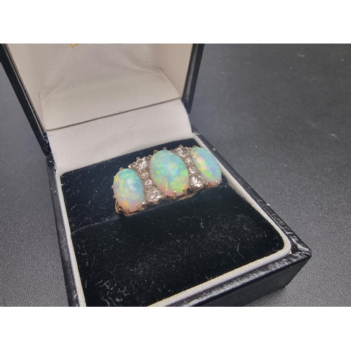 174 - A yellow metal ring, set three cabochon opals and eight graduated mine cut diamonds, size O.... 