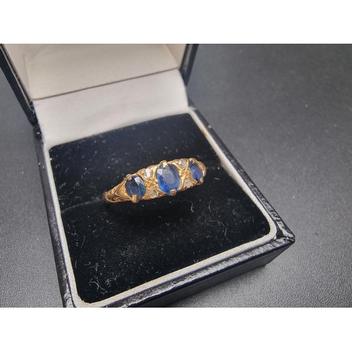 176 - A Victorian yellow metal ring, set three oval sapphires and four diamond chips, size N 1/2.... 