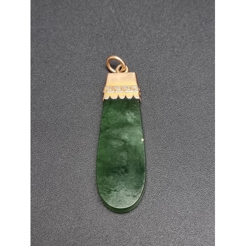 185 - A yellow metal jadeite pendant, stamped '18c', 46mm including bale.