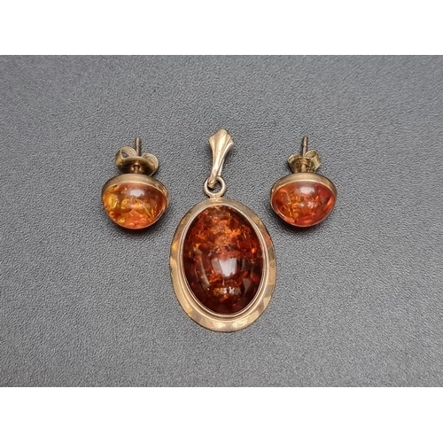 186 - A pair of 9ct gold amber stud earrings; together with a 9ct gold amber pendant. (3)