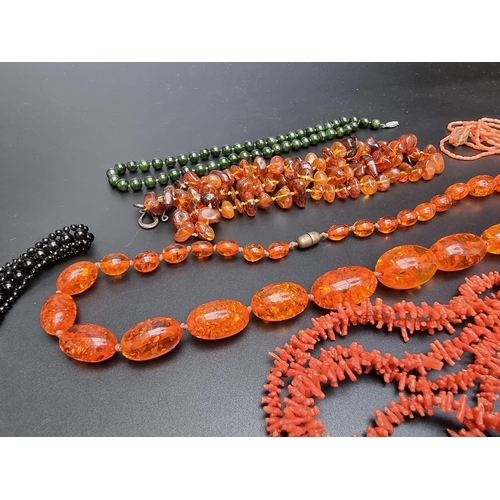 222 - An amber necklace, having clasp stamped '925 Sterling', 81cm; together with two coral necklaces; fou... 