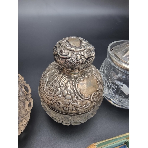 67 - Two silver mounted cut glass scent bottles; together with a silver lidded cut glass preserve jar; a ... 