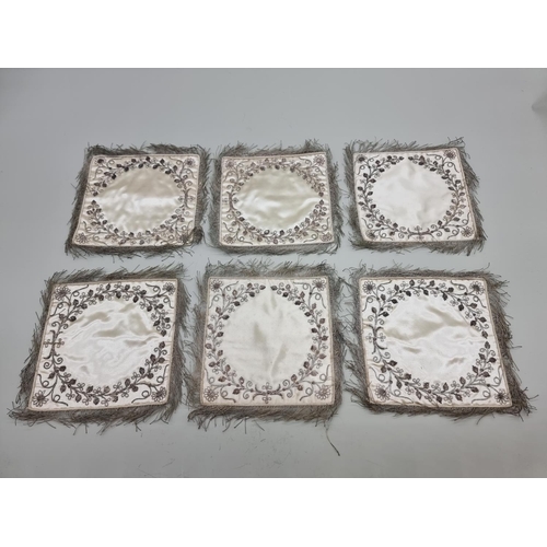 1402 - A set of six metal thread embroidered silk doilies.