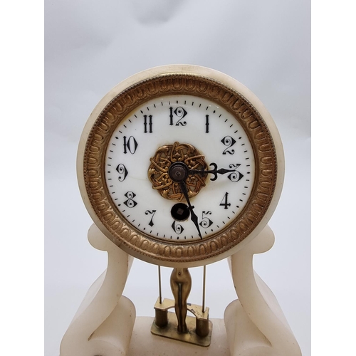 1503 - A late 19th century French alabaster portico style timepiece, with novelty brass nude on swing pendu... 