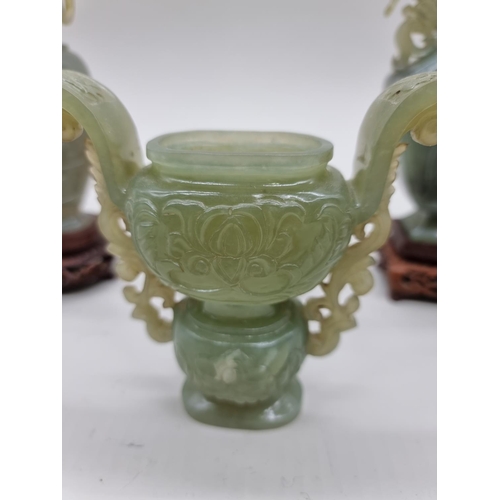 1604 - Three Chinese carved green jade twin handled vases and covers, 22cm high; together with another... 