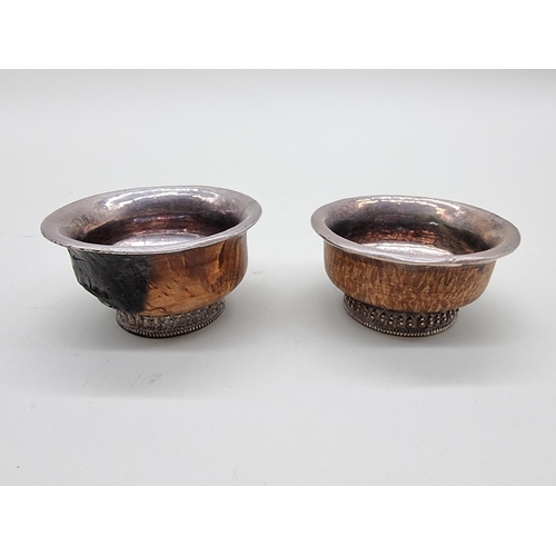 1606 - A small pair of burr wood and white metal mounted bowls, 7cm diameter. 