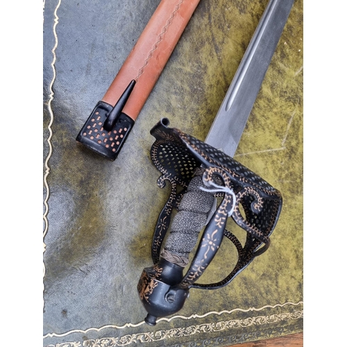 1703 - A reproduction basket hilt sword and leather scabbard, with 83cm blade.