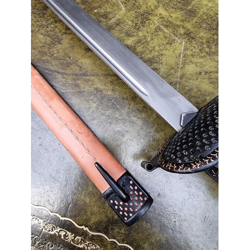 1703 - A reproduction basket hilt sword and leather scabbard, with 83cm blade.