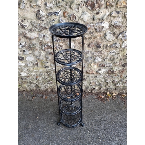 1748 - A black painted metal six tier pan stand, 123cm high.