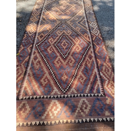 1013 - A large Afghan Kelim carpet, having two geometric medallions, 407cm x 165cm, (a.f.).... 