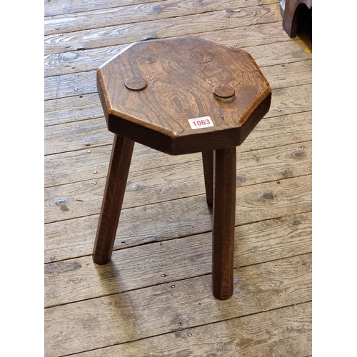 1063 - An antique elm and oak octagonal milking stool, 26.5cm wide.  