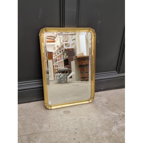 1064 - An old brass frame wall mirror, with bevelled plate, 66.5 x 46.5cm.