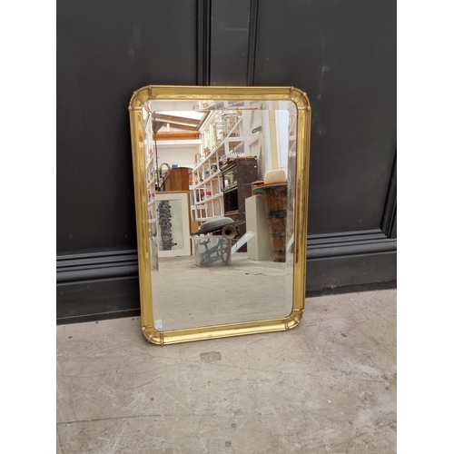 1064 - An old brass frame wall mirror, with bevelled plate, 66.5 x 46.5cm.