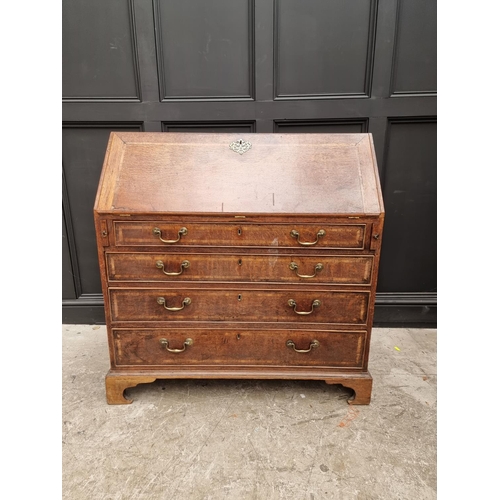 1099 - A George III oak and walnut crossbanded bureau, 106.5cm wide.  