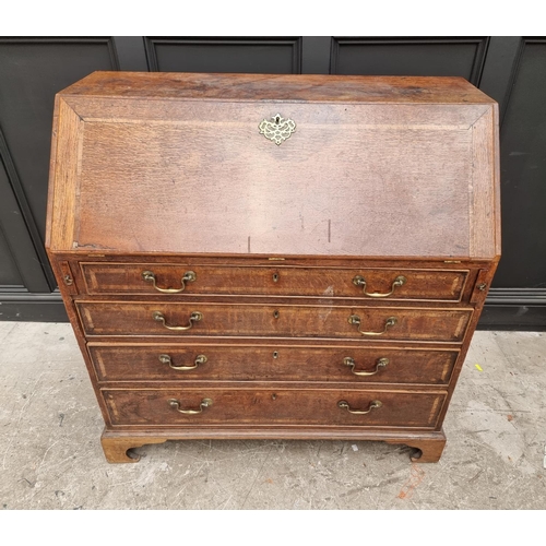 1099 - A George III oak and walnut crossbanded bureau, 106.5cm wide.  