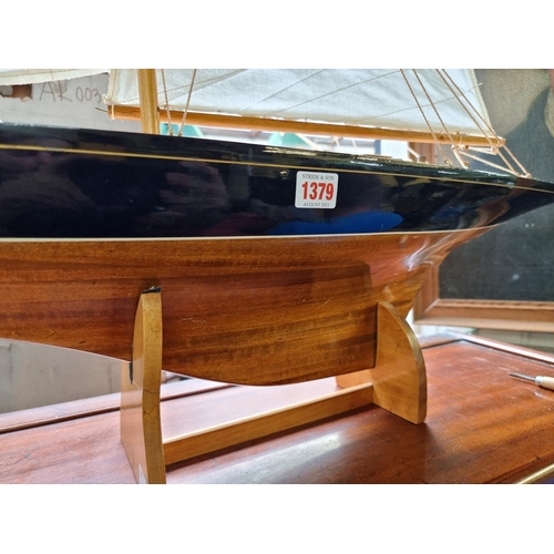 1379 - A wooden J Class pond yacht, 90.5cm long, on stand, (lacking rudder).