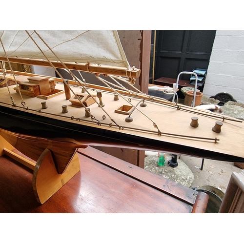 1379 - A wooden J Class pond yacht, 90.5cm long, on stand, (lacking rudder).