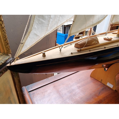 1379 - A wooden J Class pond yacht, 90.5cm long, on stand, (lacking rudder).