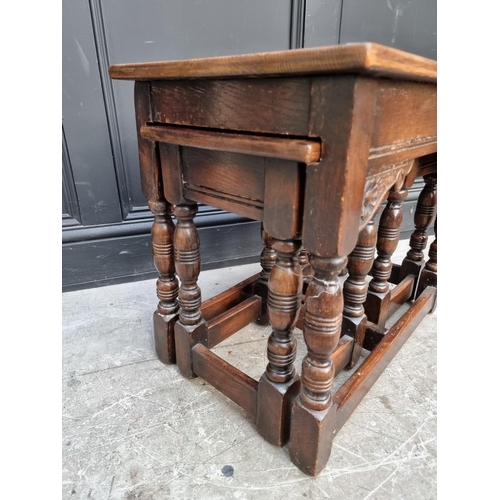 1014 - A nest of three oak occasional tables, largest 61cm wide.