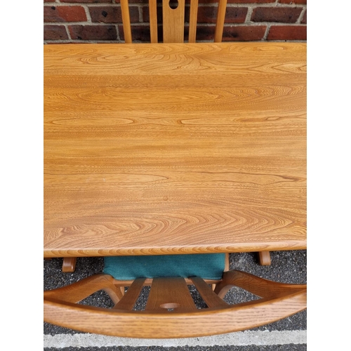 1018 - An Ercol elm dining table and four chairs, to include a pair of elbow chairs, the table 152.5cm long... 