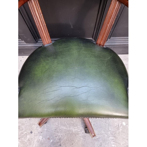 1030 - A reproduction mahogany and green leather desk chair. 