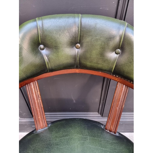 1030 - A reproduction mahogany and green leather desk chair. 