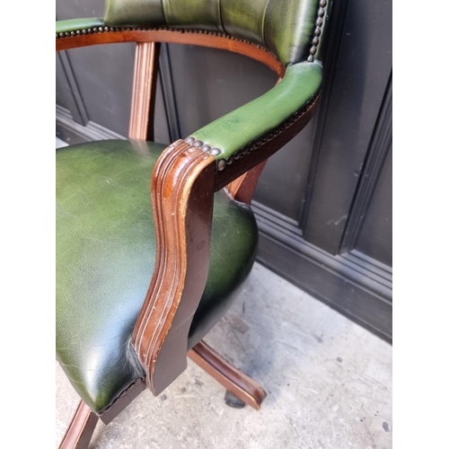 1030 - A reproduction mahogany and green leather desk chair. 