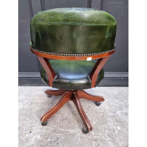 1030 - A reproduction mahogany and green leather desk chair. 