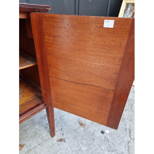 1040 - An Edwardian mahogany and inlaid bedroom suite, comprising: a triple wardrobe, 200.5cm wide; a mirro... 