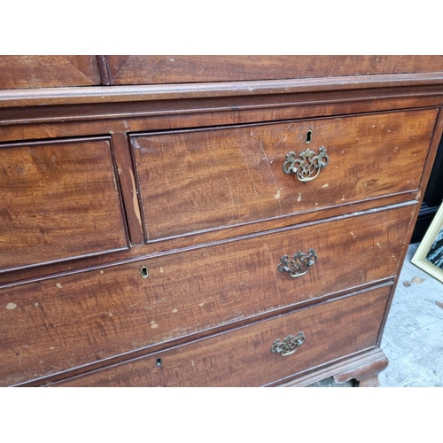 1068 - A George III mahogany linen press, enclosing four sliding trays, 131cm wide.