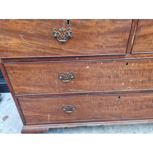 1068 - A George III mahogany linen press, enclosing four sliding trays, 131cm wide.