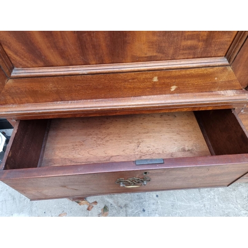 1068 - A George III mahogany linen press, enclosing four sliding trays, 131cm wide.