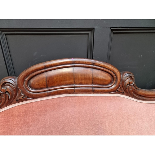 1076 - A Victorian mahogany and button upholstered scroll arm settee, 221cm wide.