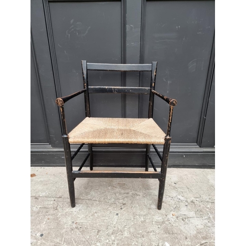 1077 - A ebonized and rush seated Sussex style chair. 