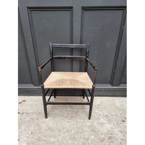 1077 - A ebonized and rush seated Sussex style chair. 