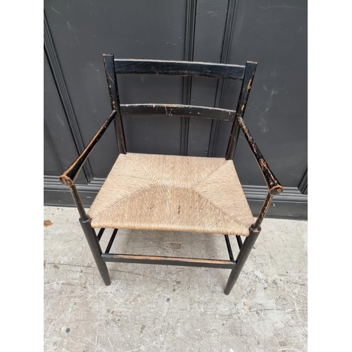 1077 - A ebonized and rush seated Sussex style chair. 