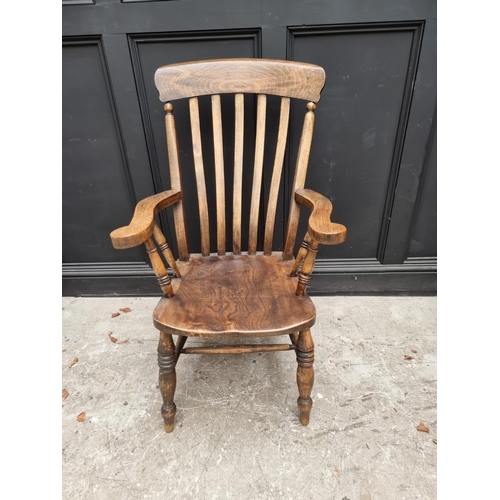 1079 - An old ash, elm and beech lath back elbow chair; together with another ash, elm and beech Windsor ar... 