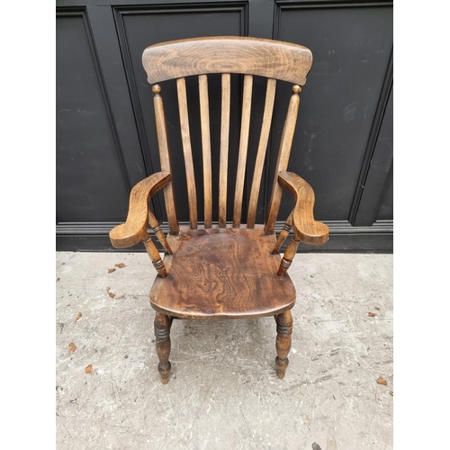 1079 - An old ash, elm and beech lath back elbow chair; together with another ash, elm and beech Windsor ar... 