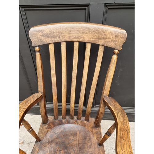 1079 - An old ash, elm and beech lath back elbow chair; together with another ash, elm and beech Windsor ar... 