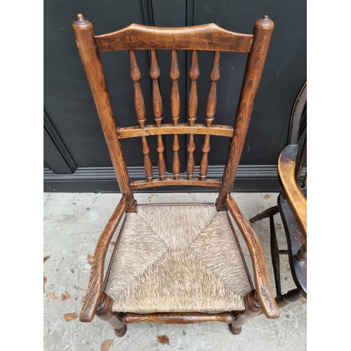 1080 - A small Victorian ash and rush spindle back elbow chair; together with another wheelback chair. (2)... 