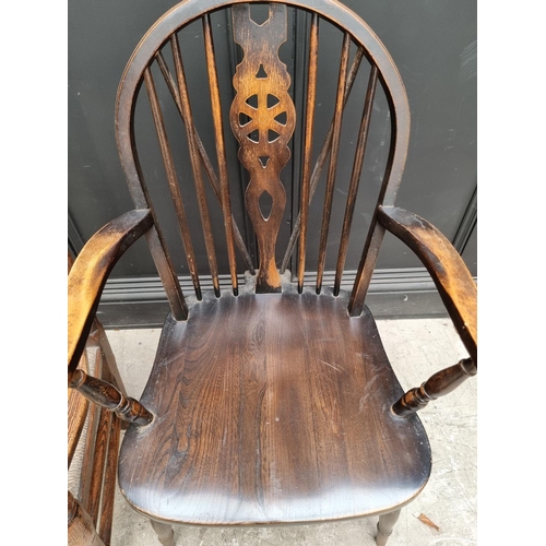 1080 - A small Victorian ash and rush spindle back elbow chair; together with another wheelback chair. (2)... 