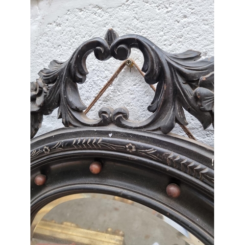 1090 - An antique ebonized circular wall mirror, 59cm diameter. 