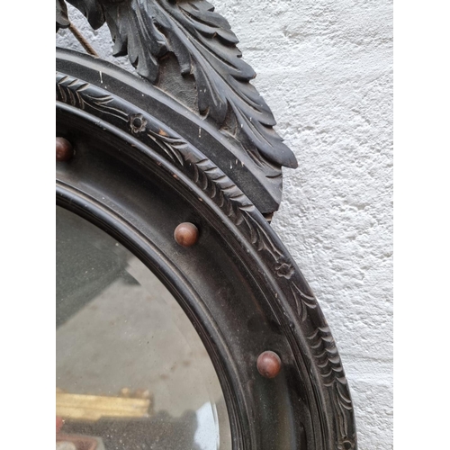 1090 - An antique ebonized circular wall mirror, 59cm diameter. 