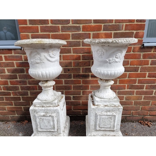 1120 - A pair of white painted composition stone Campana urns and pedestals, 109cm high.