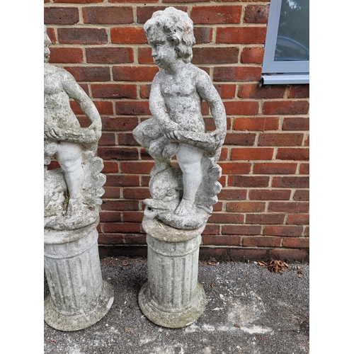 1121 - A pair of old painted and weathered composition stone cherub and dolphin figures, on pedestals, 128c... 