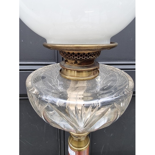 1057 - A red marble and brass mounted oil lamp, height excluding chimney 79.5cm.  ... 