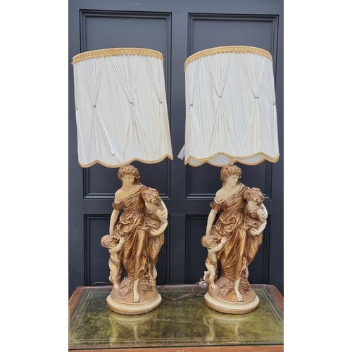 1070 - A large pair of cream and gilt painted plaster figural table lamps, height including shades 127... 