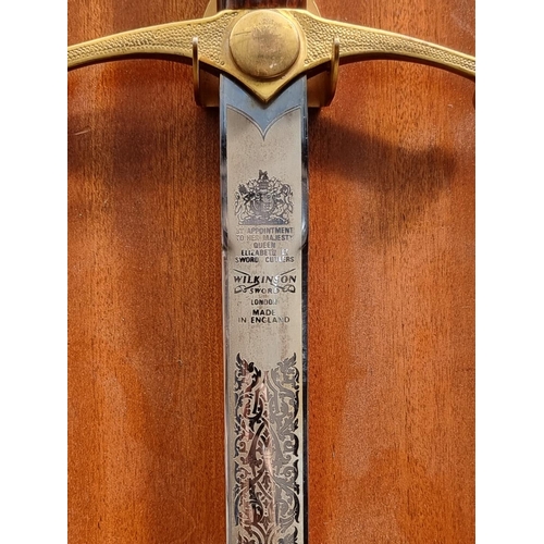 1342 - A modern twin handled broadsword, by Wilkinson, total length 108cm, on wall mounted display stand.&n... 