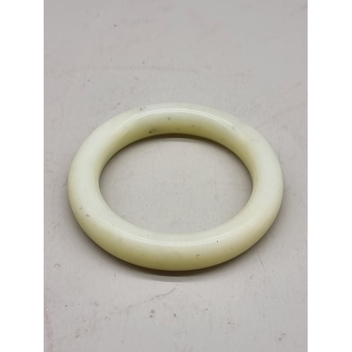 1462 - A Chinese celadon jade bangle, 9cm diameter.